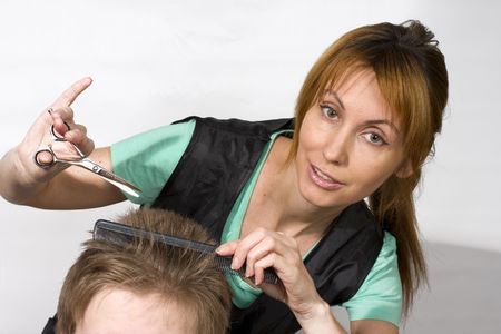 Pretty woman hairdresser cuts clientの写真素材
