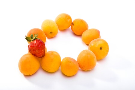 Ripe apricots and berry of strawberry on white backgroundの写真素材
