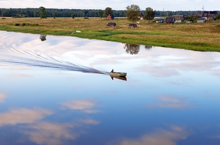 The boat floats down the river on a sunset