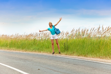 Hitchhiking girl votes on roadの写真素材