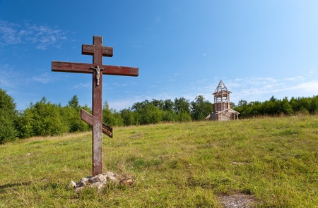 Cross in honor of the basis of church and under construction orthodox church on a hillの写真素材