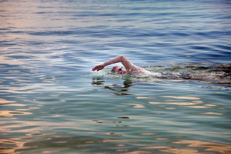  young sporting man swims in the sea の写真素材