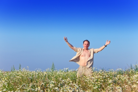 The happy young man  in the field of chamomiles

の写真素材