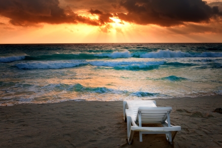 Empty beach chair before sea. Bright sunset, wavesの写真素材