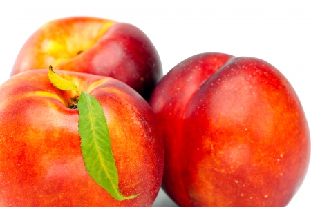 Ripe nectarine with a green leaf on a white background

の写真素材