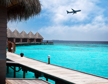 Lodges over water and the plane in the sky - tropical paradiseのeditorial素材