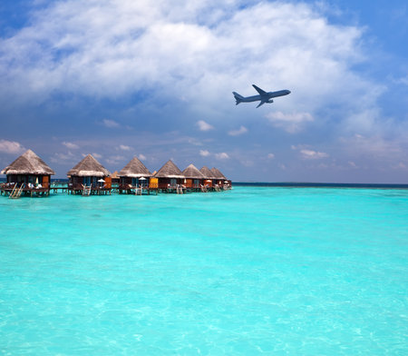 Lodges over water and the plane in the sky - tropical paradiseのeditorial素材