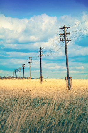Old wooden electric pillar in the field,with a retro effectの写真素材