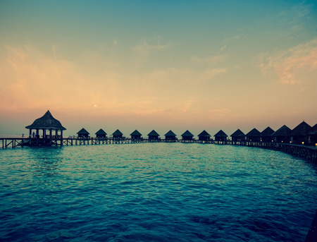 houses over the transparent quiet sea water  on a sunset,with a retro effectの写真素材