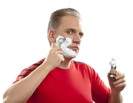 The sports man has a shave- with the razor and a small brushの写真素材