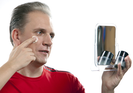 The mature man applies the cream which is looking after face skinの写真素材