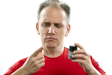 confused man the first time tries a man's against wrinkles cream