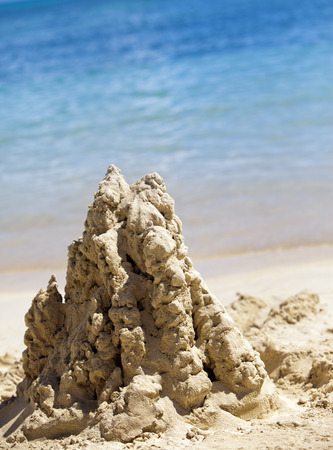sandy castle at the sea edgeの写真素材