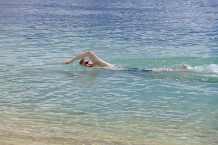 young sporting man swims in the seaの写真素材