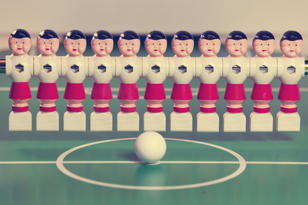 toy football players stand in the field in a row and a ball in the center, retro effect

の写真素材