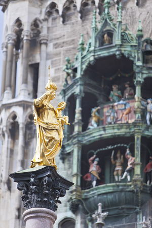 The Golden statue of Mary (Mariensaule) and dancing dolls of Town Hall at Marienplatz in Munich, Germany.の写真素材