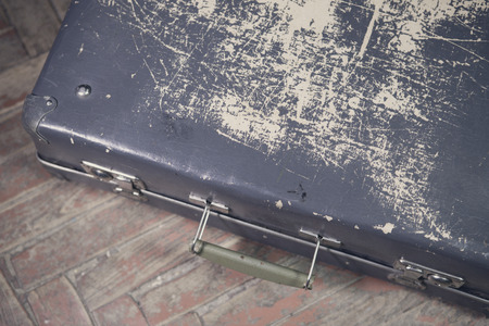 Old shabby suitcase on latches on a wooden floorの写真素材
