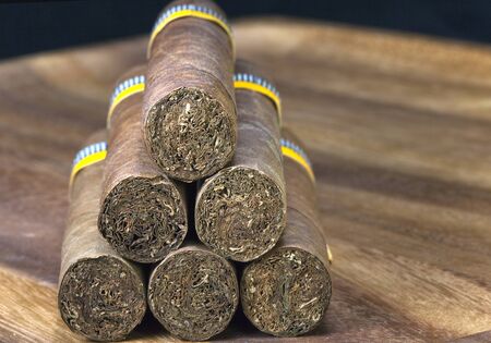 rolled cigars from a tobacco leaf on a wooden background