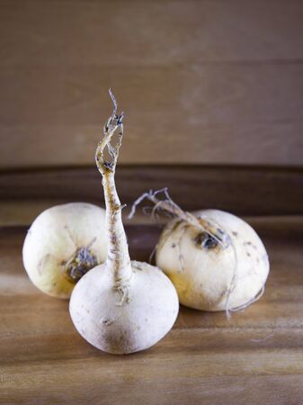three turnips on a wooden tableの写真素材