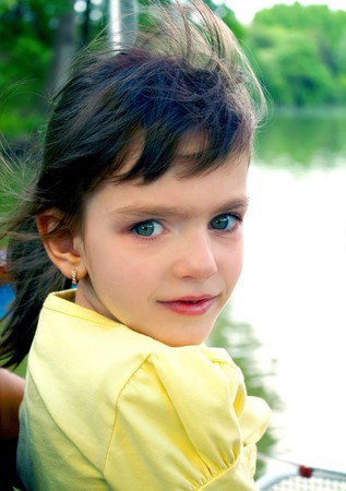 little girl in a yellow blouse with developing hair on natureの写真素材