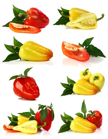 red and yellow pepper and green leaf isolated on white backgroundの写真素材
