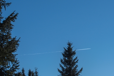 A trail of condensed vapors behind a traffic plane in the sky.の写真素材