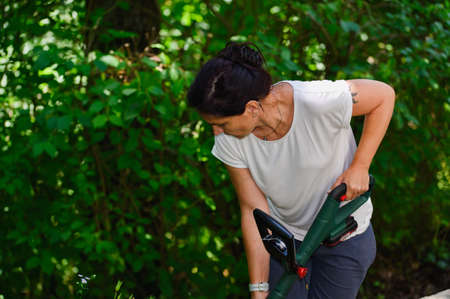 Young woman mows the grass.の写真素材