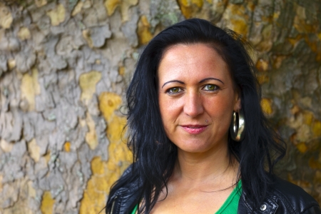 Portrait of a mid adult woman in background a plante-tree, outdoor in a small city Dillingen, Saarland   Germanyの写真素材