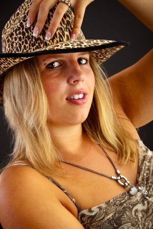 Young blond woman with hat on black backgroundの写真素材