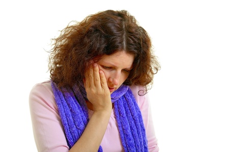 Young brown-haired woman with wool scarf has toothache, isolated on white backgroundの写真素材