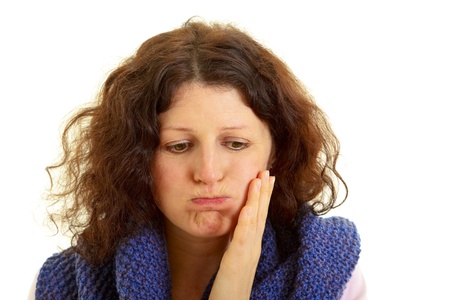 Young brown-haired woman with wool scarf has toothache, isolated on white backgroundの写真素材
