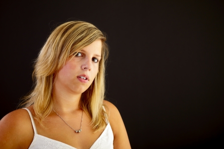 Young blond woman on black background, studio shot. の写真素材