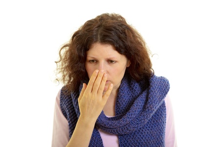 Young brown-haired woman with wool scarf sniffs the hand, isolated on white background, studio shot. の写真素材
