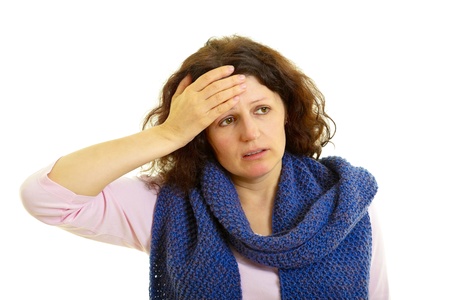 Young brown-haired woman with wool scarf has headache, isolated on white background, studio shot.の写真素材