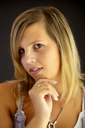 Young blond woman on black background, studio shot. の写真素材