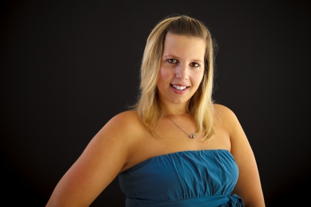 Young blond woman on black background, studio shot.の写真素材