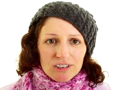 Young brown-haired woman with  a wool  cap makes funny facial expression, isolated on white background, studio shot. Adobe RGBの写真素材
