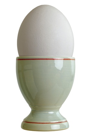 Closeup of a eggcup with chicken egg, isolated on white backgroundの写真素材