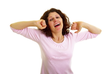Young woman with brown hair  yawns and stretches, isolated on white background, studio shot  Adobe RGBの写真素材