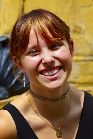 Portrait of a young woman in background sandstone wall, outdoor in a small city Saarlouis / Saarland / Germanyの写真素材