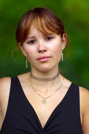 Portrait of a young woman  on a green background, outdoor in a small city Saarlouis. Saarland / Germanyの写真素材