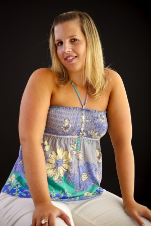 Young blond woman on black background, studio shot. の写真素材