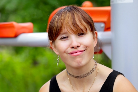 A young woman sitting on sport device and laughs in the pause between sport exercises  Outdoor in park in city Saarlouis, Saarland   Germany の写真素材