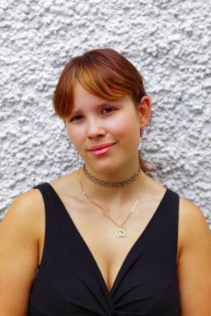 Portrait of a young woman in background a white wall, outdoor in a small city Saarlouis / Germanyの写真素材