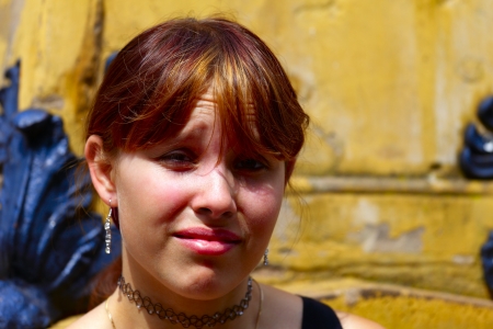 Portrait of a young woman in the background a sandstone  wall,  in small city Saarlouis, Saarland / Germanyの写真素材