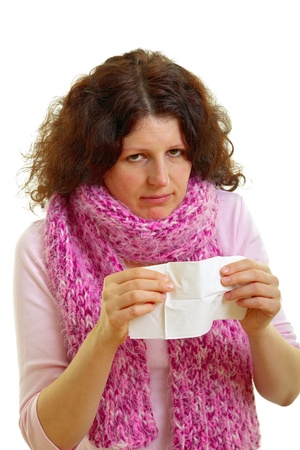 Young woman with brown hair blows his nose, isolated on white background, studio shot.の写真素材