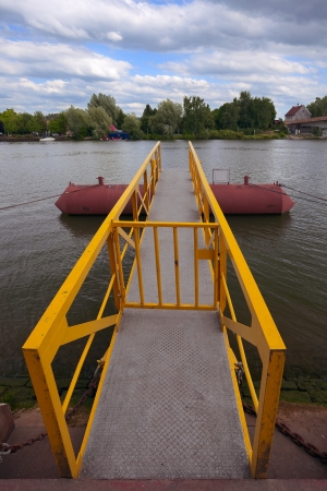View of a small pier on river Moselle border river  in city Remich   Luxembourg, evening, summer, in the distance to right  a campground in Germanyの写真素材