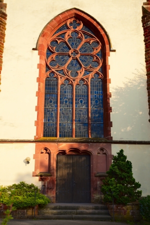 View of the steined glass window and door by church in Besseringen, Saarland / Germany, evening sun, summerの写真素材