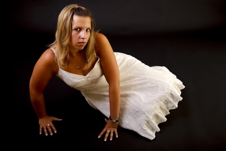 Young blond woman on black background, studio shot. の写真素材