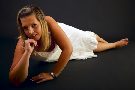 Young blond woman on black background, studio shot. の写真素材